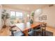 Bright dining room features a large window, hardwood floors, and a modern table with seating at 6892 Juniper Ct, Arvada, CO 80007