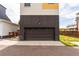 Attached garage on a modern home with brown horizontal siding and a concrete driveway at 6892 Juniper Ct, Arvada, CO 80007