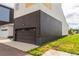 Attached garage on a modern home with brown horizontal siding and a concrete driveway at 6892 Juniper Ct, Arvada, CO 80007