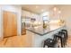 Modern kitchen boasts stainless steel appliances, sleek countertops, and a breakfast bar with stools at 6892 Juniper Ct, Arvada, CO 80007