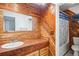 Rustic bathroom featuring wood walls, a vessel sink, and a shower with decorative curtain at 7995 E Mississippi Ave # J1, Denver, CO 80247