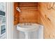 Charming powder room featuring wood paneling, vintage-style pedestal sink, and classic fixtures at 7995 E Mississippi Ave # J1, Denver, CO 80247