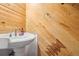 Powder room with pedestal sink and wood-paneled walls at 7995 E Mississippi Ave # J1, Denver, CO 80247