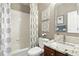 Well-lit bathroom featuring a shower-tub combo, a granite countertop vanity, and a decorative mirror at 10601 Chadsworth Ln, Highlands Ranch, CO 80126