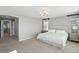 Bright bedroom with neutral decor, carpet, and large bed illuminated by a modern chandelier at 10601 Chadsworth Ln, Highlands Ranch, CO 80126