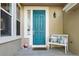 Close-up of a teal front door entrance featuring charming decor and a welcoming bench at 10601 Chadsworth Ln, Highlands Ranch, CO 80126