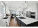 Spacious kitchen featuring a large island with cooktop and pendant lighting, flowing into the bright living room at 10601 Chadsworth Ln, Highlands Ranch, CO 80126