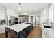 Open kitchen with a large island, stainless steel appliances, pendant lighting, and hardwood floors at 10601 Chadsworth Ln, Highlands Ranch, CO 80126