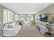 Bright living room featuring white couches, plantation shutters, and a contemporary entertainment center at 10601 Chadsworth Ln, Highlands Ranch, CO 80126