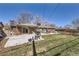 Spacious backyard featuring a brick house, patio, lush grass, and mature trees at 2674 S Krameria St, Denver, CO 80222