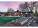 Spacious backyard with a patio, garden beds, mature trees, and an outdoor seating area at 2674 S Krameria St, Denver, CO 80222