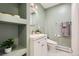 Stylish bathroom featuring a modern vanity, round mirror, and open shelving for decor at 2674 S Krameria St, Denver, CO 80222