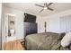Spacious bedroom with hardwood floors, ceiling fan, and a large mounted TV at 2674 S Krameria St, Denver, CO 80222