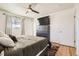 Well-lit bedroom with hardwood floors, ceiling fan, and a large mounted TV at 2674 S Krameria St, Denver, CO 80222