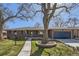 Inviting brick home featuring a well-kept front yard, mature trees, and an attached garage at 2674 S Krameria St, Denver, CO 80222