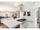 Open kitchen with large island, stainless steel vent hood, and seamless flow to living area at 2674 S Krameria St, Denver, CO 80222