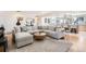Bright living room featuring a large sectional, modern round coffee table, and an open concept to the kitchen at 2674 S Krameria St, Denver, CO 80222