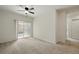 Bright living room with plush carpet, balcony access, and ceiling fan at 1881 S Dunkirk St # 106, Aurora, CO 80017
