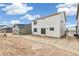 Rear view of the house showcasing light siding, windows, and a sliding door leading to an unfinished backyard at 20724 E 57Th Ave, Aurora, CO 80019