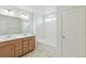 Bathroom featuring double vanity, large mirror, tub with tile surround, and tiled floors at 20724 E 57Th Ave, Aurora, CO 80019
