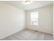 A simple and clean bedroom with a carpeted floor, one window, and white walls at 20724 E 57Th Ave, Aurora, CO 80019