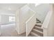 Bright hallway with carpeted staircase and a doorway leading to a room with large windows at 20724 E 57Th Ave, Aurora, CO 80019