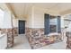 Inviting porch featuring stone columns, dark front door, tasteful shutters, and neutral siding at 20724 E 57Th Ave, Aurora, CO 80019