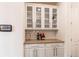 Elegant bar area with glass-front cabinets, granite countertop, and decorative bottles at 8107 Arapahoe Peak St, Littleton, CO 80125