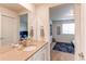 Bright bathroom featuring modern fixtures, a spacious countertop, and a view into the adjacent bedroom at 8107 Arapahoe Peak St, Littleton, CO 80125