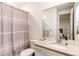 Bathroom with a shower and tub, a vanity with modern hardware, and a large mirror reflecting natural light at 8107 Arapahoe Peak St, Littleton, CO 80125