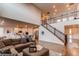 Bright living room with open floor plan, stairs, comfortable seating, and access to modern kitchen at 8107 Arapahoe Peak St, Littleton, CO 80125