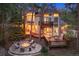 A backyard featuring a stone patio with fire pit, tiered decks, and lush wooded surroundings create a private retreat at 510 Castle Pines Dr, Castle Rock, CO 80108