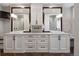 Luxury bathroom boasts double vanity with lots of storage and lighting over herringbone floors at 510 Castle Pines Dr, Castle Rock, CO 80108