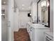 Elegant bathroom with double sinks, custom cabinets, herringbone floors, and a glass-enclosed shower at 510 Castle Pines Dr, Castle Rock, CO 80108