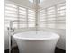 Bright bathroom featuring a freestanding soaking tub beneath windows with horizontal shades and white subway tile at 510 Castle Pines Dr, Castle Rock, CO 80108