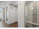 Hallway with decorative floor tile leading to modern bathroom with frameless shower with mosaic inlay at 510 Castle Pines Dr, Castle Rock, CO 80108