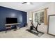 Exercise room with a mounted TV, wood accent wall, natural light, and an exercise bike at 510 Castle Pines Dr, Castle Rock, CO 80108