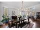 Inviting dining room with hardwood floors, elegant chandelier, and views of the wooded landscape through large windows at 510 Castle Pines Dr, Castle Rock, CO 80108