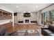 Bright living room features hardwood floors, a stone fireplace, built-in shelves, and sliding glass doors to the deck at 510 Castle Pines Dr, Castle Rock, CO 80108