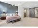 Main bedroom showcases blue accent wall, ceiling fan, seating bench, and ensuite bathroom with barn door at 510 Castle Pines Dr, Castle Rock, CO 80108