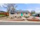 Charming home boasts a solar roof, bright turquoise front door, and beautiful brick-lined landscaping at 741 Cortez St, Denver, CO 80221