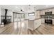 Open kitchen with an island, stainless appliances, and hardwood floors to the living area at 741 Cortez St, Denver, CO 80221