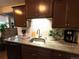 This kitchen features a stainless steel sink, granite counters, tile backsplash, and dark wood cabinets at 10702 E Exposition Ave # 101, Aurora, CO 80012