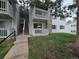 Exterior of apartments with gray siding, stone accents, and stairs to the upper unit with private balcony and manicured lawns at 14433 E Jewell Ave # 101, Aurora, CO 80012