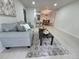 Open concept living area featuring a gray sofa, modern furnishings, and an adjacent kitchen and dining space at 14433 E Jewell Ave # 101, Aurora, CO 80012