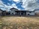 Spacious backyard with a covered patio, grass, and retaining wall for privacy at 3097 W 134Th Way, Broomfield, CO 80020