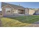Manicured backyard features a covered patio, lush lawn, and low-maintenance landscaping at 8778 S Quatar St, Aurora, CO 80016