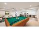 Spacious basement featuring a pool table, bar, and seating area, perfect for entertaining at 8778 S Quatar St, Aurora, CO 80016