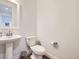 Bright half bathroom features a pedestal sink and modern fixtures at 8778 S Quatar St, Aurora, CO 80016