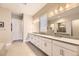 Bright bathroom with double sinks, granite countertops, white cabinets, and walk-in shower at 8778 S Quatar St, Aurora, CO 80016